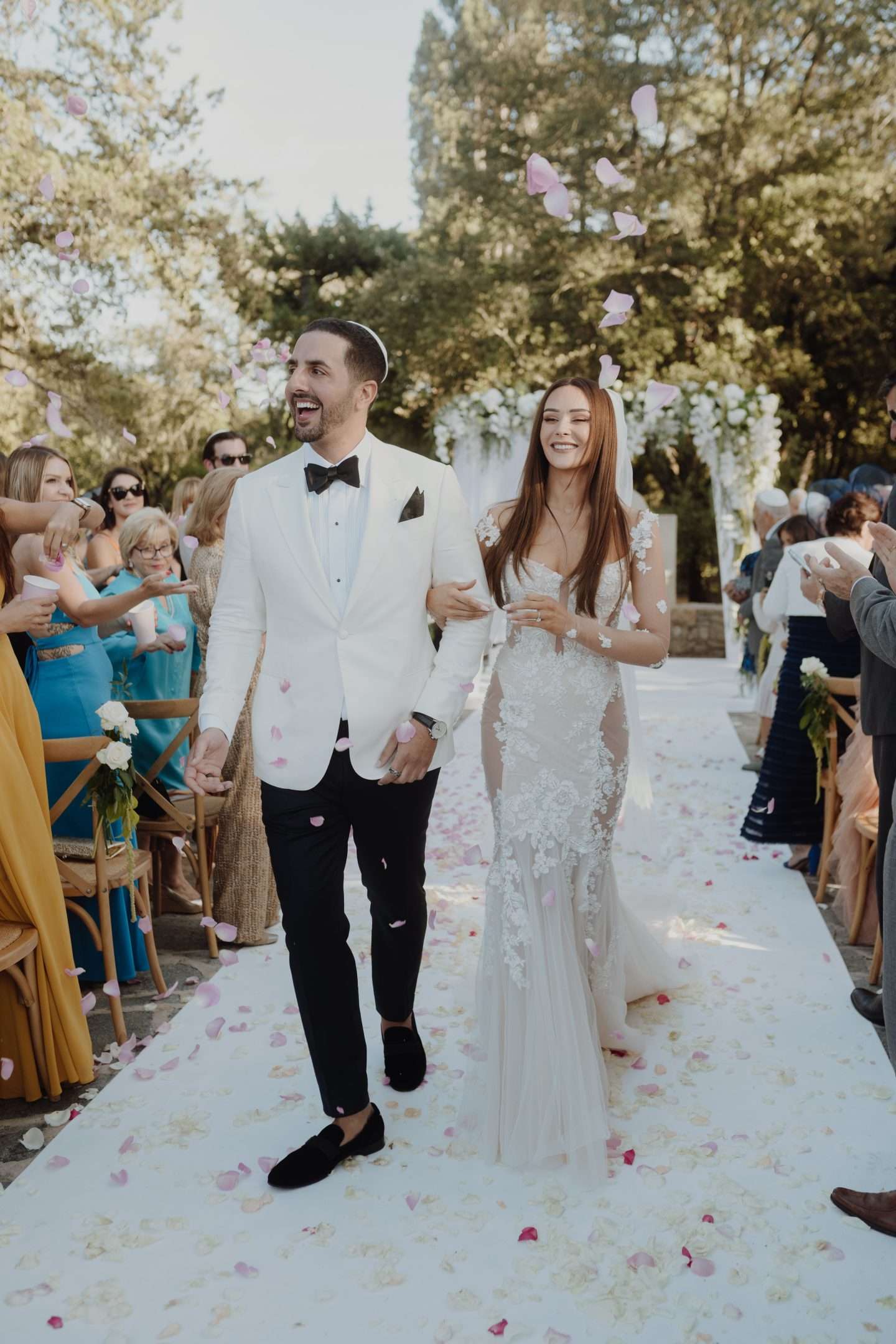 Bride and groom walking down the aisle with petals being throwed at them