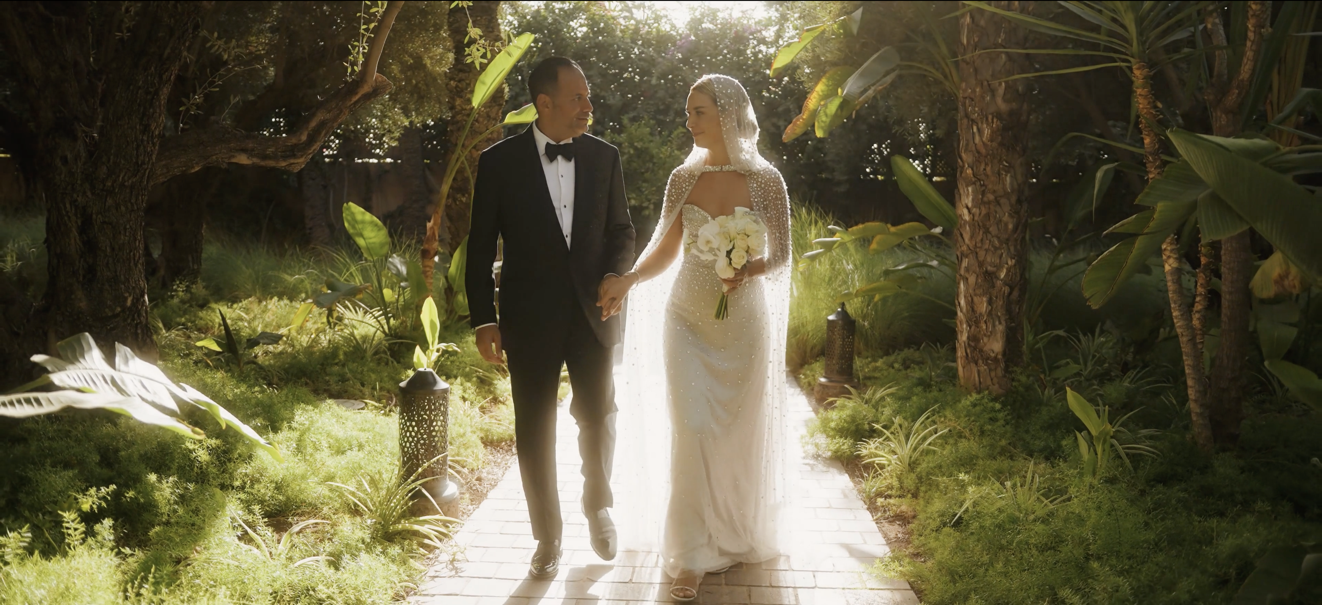 Bride and groom walking towards ceremony in the middle of vegetation