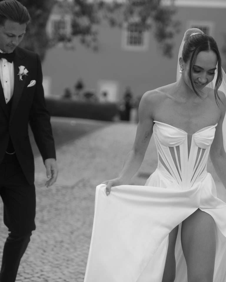 Bride walking in front of the groom opening her dress slit