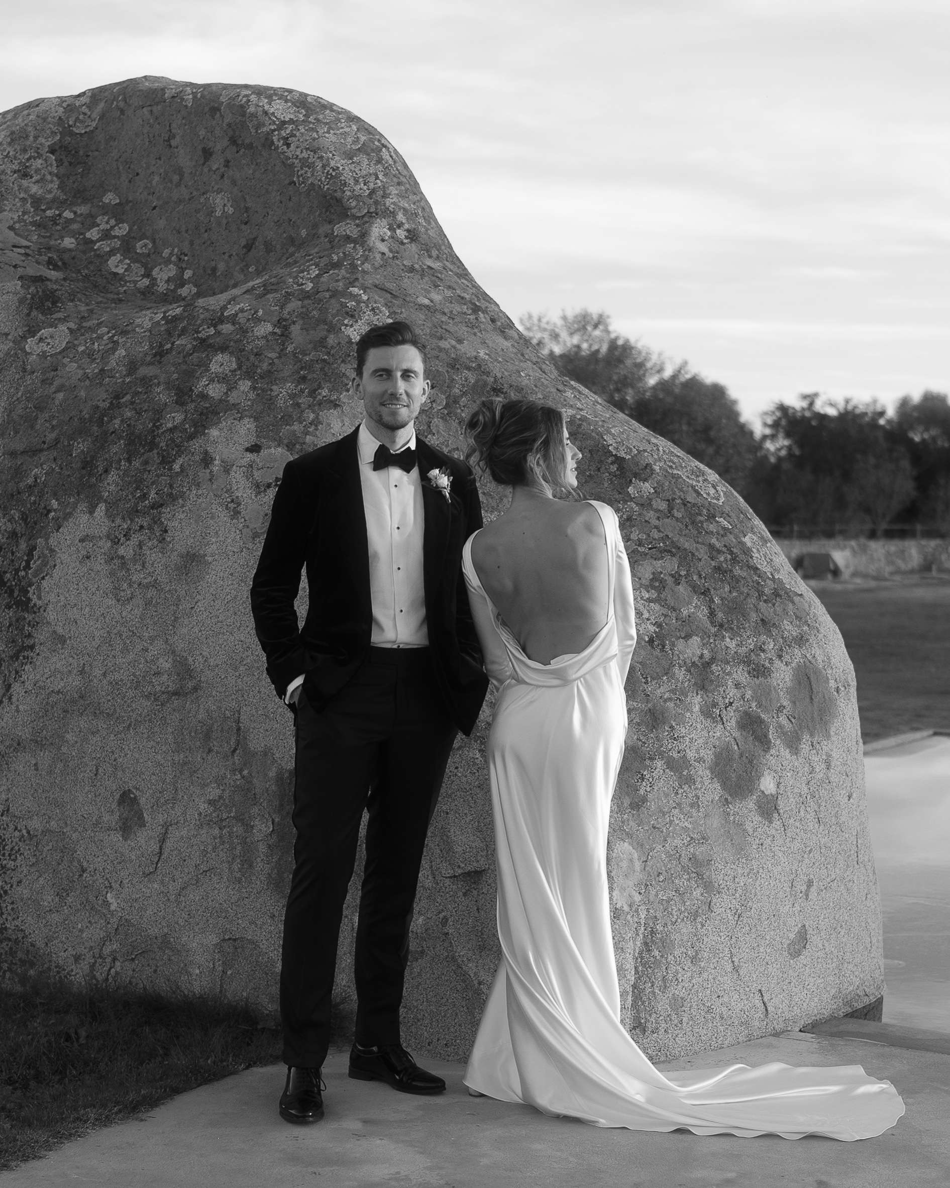 Bride and groom posing in front of a rock at s. lourenço do barrocal